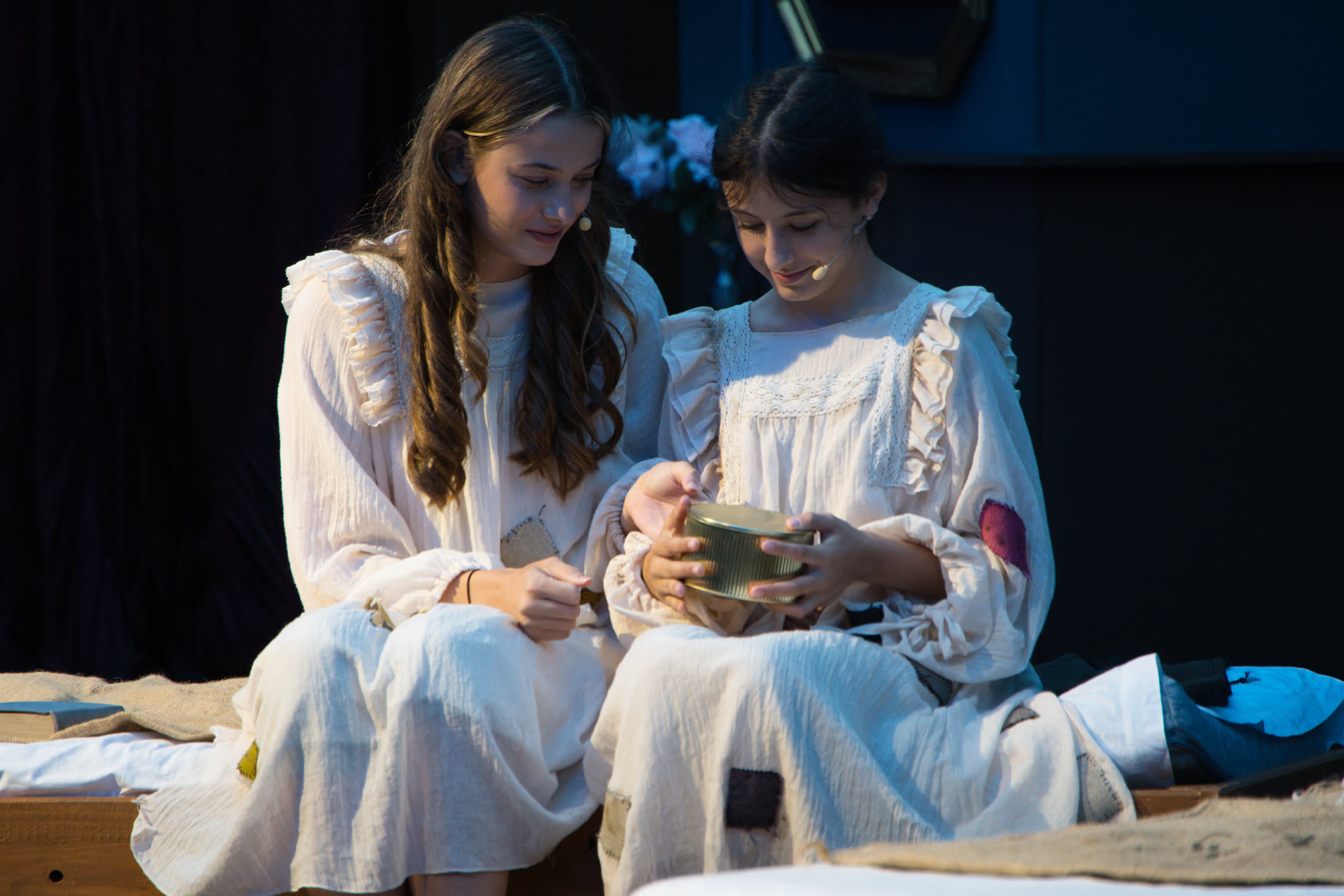 Clara (Theresa) und Mia (Sophie) lesen heimlich im Waisenhaus und teilen ihre letzten Kekse.
